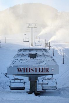 a ski lift sitting on top of a snow covered slope next to a sign that says whistle