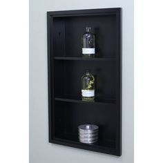 a black shelf with three bottles on it