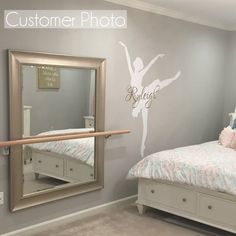 a ballerina wall decal in a bedroom next to a bed with a mirror