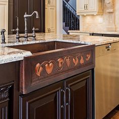 a kitchen with an ornate sink and marble counter tops