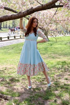 Our Storybook Farm Dress is simply dreamy! In gorgeous shades of aqua and mauve pink, it has a flattering empire bodice and is midi length with a sewn in petticoat. Fully lined and with contrasting trim throughout. Made from 100% cotton. Sewn in the U.S.A. Made in USA100% CottonFully LinedMidi DressBack Zipper3/4 Sleeve Spring Midi Dress With Fitted Bodice For Dressmaking, Spring Fit And Flare Dress With Empire Waist, Spring Fit And Flare Empire Waist Dress, Blue Dresses With Fitted Bodice For Garden Party, Summer Turquoise Knee-length Midi Dress, Knee-length Turquoise Summer Midi Dress, Turquoise Knee-length Summer Midi Dress, Spring Empire Waist Midi Dress With Ruffles, Spring Midi Dress With Ruffles And Empire Waist