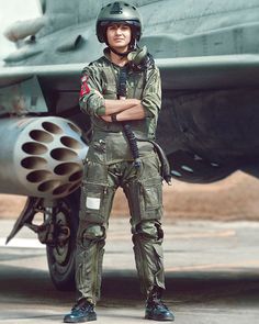 a man standing in front of an airplane with his arms crossed and looking at the camera