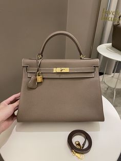 Hermes Kelly 32Etoupe Togo GHWSize 32 x 21 x 12 cmStrap drop 45 cmD StampDec 20199.8-9.9/10 New Kept Unused (minimal storage sign if any otherwise like new)Includes full set box dust bag (not perfect), raincoat, lock, keys and receiptPrice now 19,300 sgd 14,600 usd CN5174-02 Hermes Bag Outfit, Hermes Kelly 32, Minimal Storage, Kelly 32, Hermes Kelly Bag, Ysl Shoes, Jimmy Choo Sunglasses, Kelly Bag, Fendi Shoes