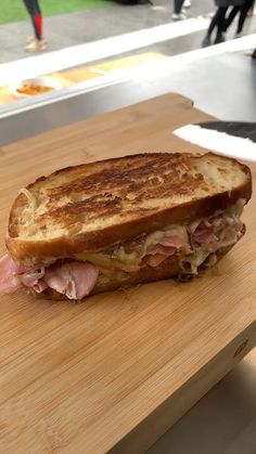 a sandwich sitting on top of a wooden cutting board