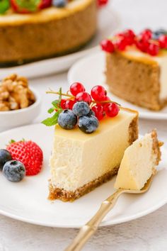 a slice of cheesecake with berries and walnuts on the side next to it