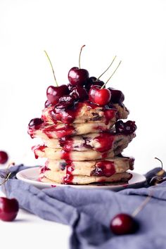 a stack of pancakes with cherries on top