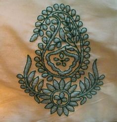 an embroidered design on a white sheet with green leaves