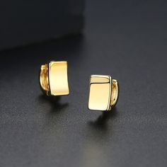 Minimalist huggie earrings with a curved geometric shape, crafted from gleaming 18k gold-plated metal. 0.24" W x 0.35" L 18k gold-plated copper Gold Rectangular Huggie Earrings, Gold Rectangular Minimalist Huggie Earrings, Gold Minimalist Huggie Earrings For Formal Events, Gold Minimalist Huggie Earrings For Formal Occasions, Gold Rectangular Huggie Earrings For Everyday, Everyday Gold Square Huggie Earrings, Gold Square Huggie Earrings, Rectangular Yellow Gold Huggie Earrings Minimalist Style, Gold Square Minimalist Huggie Earrings