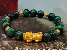 Gift yourself or your loveonce this beautiful Pure Gold Pixiu Bracelet.  *Materials: Au999 Pure Gold, Tiger's Eye Stone *Karat: 24K Pure Gold  *Gold Color: Yellow *Gold Weight: Approx. 2g APPROXIMATE SIZE Pixiu Length: .84 Inches Pixiu Width: .40 Inches Mantra Ball: 6mm Tiger's Eye Stone: 10mm 🔸️Pi Xiu has the meaning of bringing in wealth and treasure. It is also capable of warding off evil spirits and bringing good fortune.  🔸️Money Ball is used to attract good fortune and money luck, it brings good energy and better flow of money OUR 24K GOLD IS MADE FROM 5G TECHNOLOGY What does 5G mean? 1, Grace : toughness, not easy to break 2, Gusty : light weight, high hardness 3, Genius : advanced technology, style fashion 4, Glorious : never fades 5, Gentle : high purity, full gold 999. Real 24K Spiritual Yellow Gold Beaded Bracelets As Gift, Spiritual Gold Bracelet With Round Beads As Gift, Luxury Yellow Gold Beaded Bracelets As A Gift, Spiritual Yellow Gold Round Beads Bracelets, Spiritual Yellow Gold Bracelets With Round Beads, Yellow Gold Round Beads Bracelet Gift, Yellow Gold Beaded Bangle Bracelet Gift, Yellow Gold Bangle Beaded Bracelet Gift, Yellow Gold Bracelets With Round Beads For Gifts