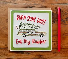 a card that says burn some duct, eat my rubber on top of a wooden table