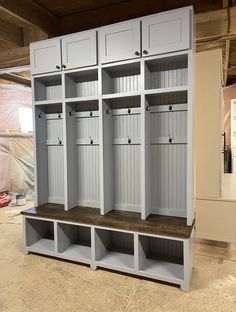 an empty room with several white lockers and shelves on the floor in front of it