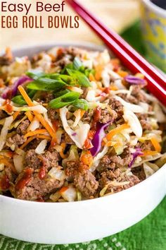 an egg roll bowl with chopsticks in it on a green tablecloth next to a red and white striped straw