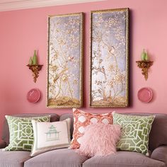 a living room with pink walls and two paintings on the wall