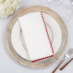 a white plate topped with a napkin next to a fork and knife on top of a table