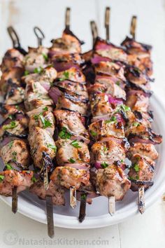 chicken kabobs on skewers with red onions and green garnish