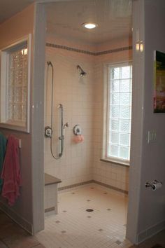 a bathroom with a walk in shower sitting next to a sink and mirror on the wall