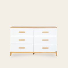 a white dresser with wooden handles and drawers