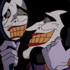 the joker is looking in the mirror with his mouth open and tongue out as if he's trying to see himself in the mirror