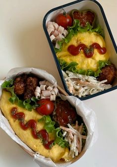 two hotdogs with ketchup, lettuce and tomatoes in wrappers