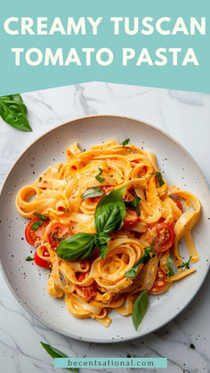 creamy tuscani pasta with basil and tomatoes on a white plate