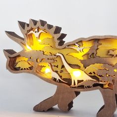 an animal shaped light up with dinosaurs on it's back and the lights turned on