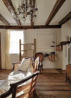 an old fashioned living room with wood floors and exposed beams on the ceiling is furnished with antique furniture