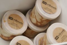 six jars of ice cream sitting on top of a white container with brown and white designs