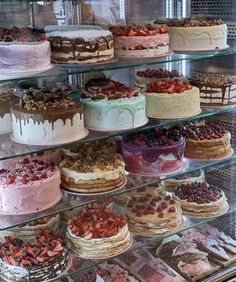 a display case filled with lots of different types of cakes