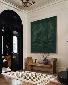 a black and white area rug in front of a doorway with a painting on the wall