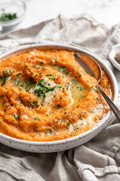 a bowl of mashed potatoes with parmesan cheese and herbs on top, ready to be eaten