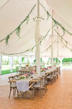 a large tent with tables and chairs under it