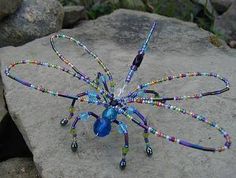 a blue spider sculpture sitting on top of a rock