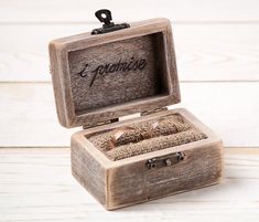 an open wooden box with two wedding rings inside