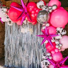 the balloon arch is decorated with pink and silver balloons