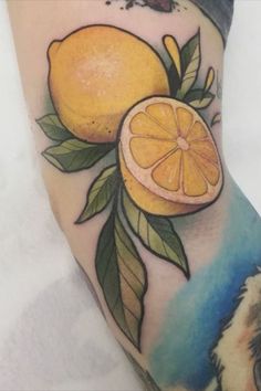 a tattoo with an orange and leaves on it