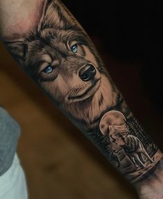 a man's arm with a wolf and an elephant tattoo on the left forearm