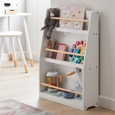 a child's book shelf in the corner of a room with toys on it