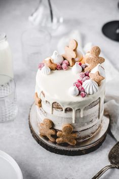 a cake with white frosting and gingerbreads on top sitting on a table