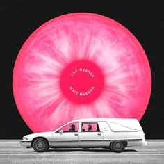 a white van parked in front of a large pink object with the words, the heart is that memory