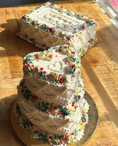 three tiered cake sitting on top of a wooden table next to a slice cut out of it