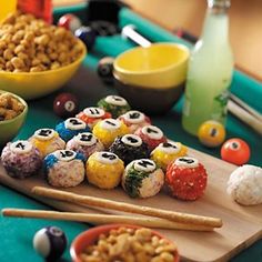 a wooden tray topped with lots of different types of food next to bowls and chopsticks