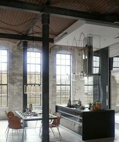 an industrial style kitchen and dining room with large windows