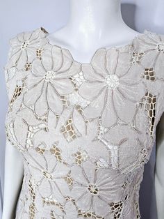 the back of a white dress with flowers on it