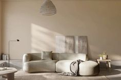 a living room filled with furniture next to a wall mounted light fixture and a painting on the wall