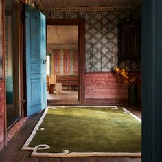 an open door leading into a room with green carpet and blue doors on both sides