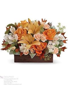 an arrangement of flowers in a wooden box