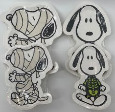 two clear plates with black and white images of snoopy and charlie the dog on them