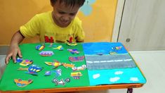 a young boy is playing with his colorful play table and chair made out of construction paper