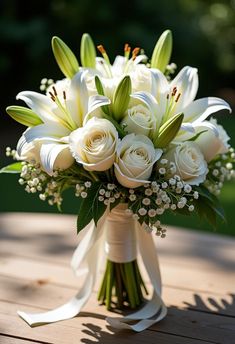 a bouquet of white flowers sitting on top of a wooden table