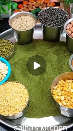 several bowls filled with different types of food on top of a metal tray in front of vegetables